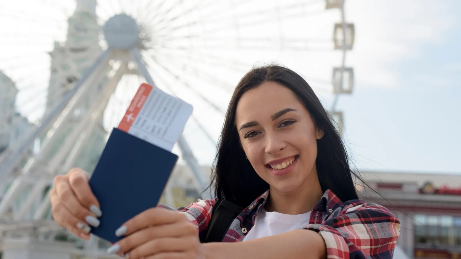 Happy traveller holding passport and boarding pass